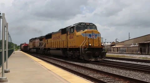 Yellow freight train pulling into station in southern texas, wide shot Video stock 65257813