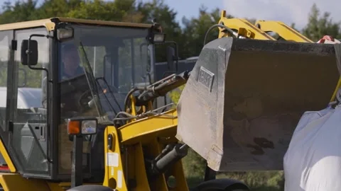 Yellow Front Loader Lifting Heavy Bulk Bag at Construction Yard Stock Footage 332978343