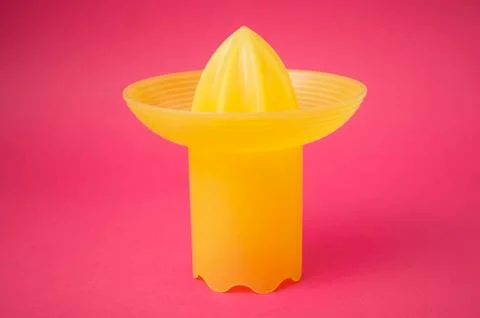 Yellow fruit squeezer on pink background Stock Photos
