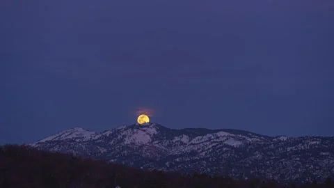 Yellow Full Moon Rising Over Snowy Mountains Vídeo Stock 336705536