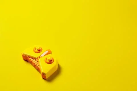 Yellow game controller on a simple yellow background. Stock Photos