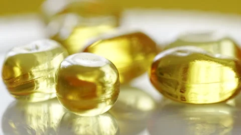 Yellow gel capsules are placed together on a white surface. Stock Footage 330592872