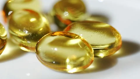 Yellow gel capsules are placed together on a white surface. Stock Footage 330592880