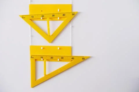 Yellow geometry tools including a protractor and triangle ruler are displayed Stock Photos