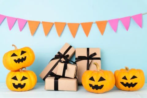 Yellow ghost pumpkin with gift box on sky blue background. halloween concept. Stock Photos