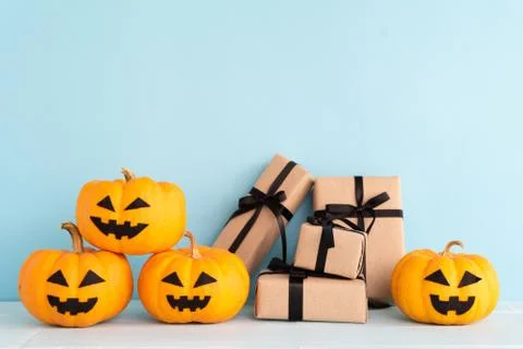 Yellow ghost pumpkin with gift box and bat on sky blue background. halloween Stock Photos