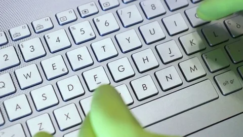 Yellow gloves typing on keyboard Stock Footage 75489202