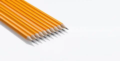 Yellow graphite pencils with sharp tips lined up on a white background. Gre.. Stock Photos