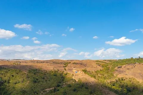 Yellow grass mountain range with bright blue sky at morning from flat angle Stockfoto's