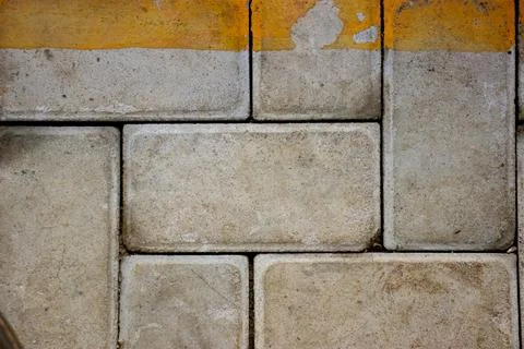 Yellow gray brick wall texture of a parking lot for background Stock Photos