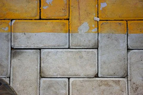 Yellow gray brick wall texture of a parking lot for background Stock Photos