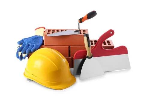 Yellow hard hat, red bricks, gloves, trowel and putty knives isolated on wh.. Stock Photos