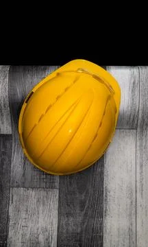 Yellow hard hat resting on construction site floor Stock Photos