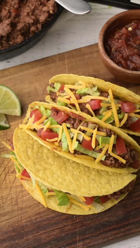 Yellow hard shell tacos on cutting board Stock-Footage 274108050
