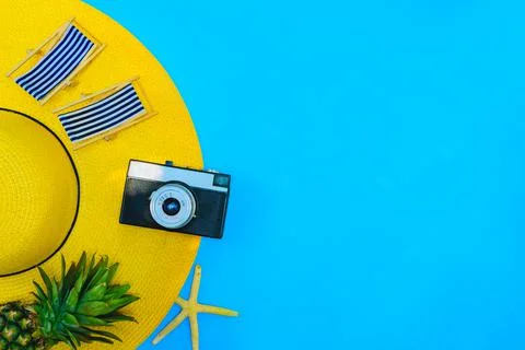 Yellow hat with camera and pineapple on blue background for Summer holiday. 库存照片