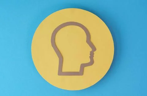 A yellow head with a brown border is on a blue background Stock Photos