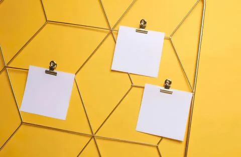 Yellow hexagon wall with three blank notes on clips Stock Photos