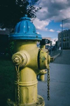 Yellow hydrant with blue cap 스톡 사진