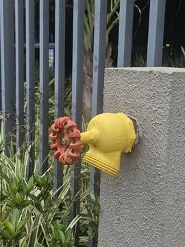 Yellow hydrant valve with a red handle Stock Photos
