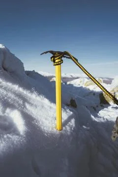 Yellow ice axe in the snow Stock Photos