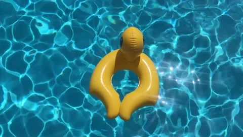 Yellow Inflatable Duck Against The Blue Water In The Pool Video stock 157987897