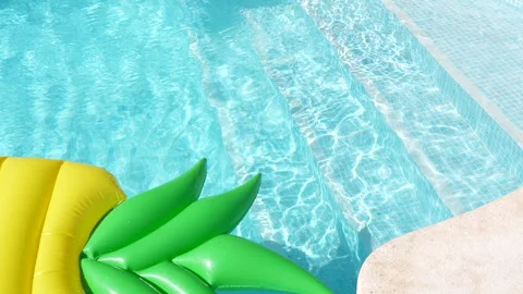 A yellow inflatable pool float with a green leaf on it is floating in a pool Stock Footage 278001019