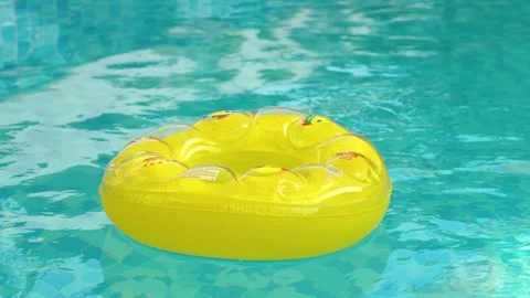 Yellow inflatable swimming ring floating peacefully on blue pool water surface Video stock 347050561