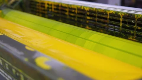 Yellow ink unit operating inside an offset industrial printing press Stock Footage 321540007