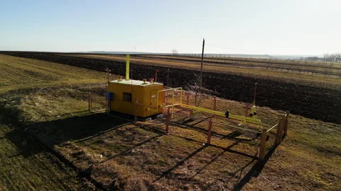 Yellow irrigation control unit positioned in agricultural field with clear blue 스톡 동영상 332894593