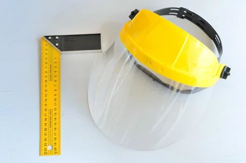 Yellow joiner's ruler and face shield for home workshop. Stock Photos