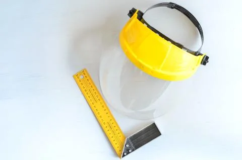 Yellow joiner's ruler and face shield for home workshop. Stock Photos