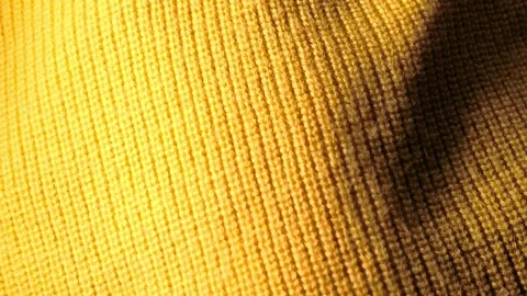 Yellow knitted fabric texture macro background showing textile weave detail and Stock Footage 336247101