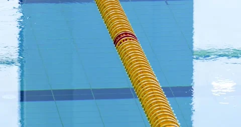 Yellow lane divider on rippled pool water, creating gentle reflections and soft Stock Footage 313594060