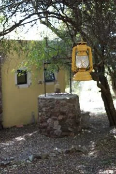 Yellow lantern hanging from a tree at the end of a house, next to an old ci.. Stock Photos