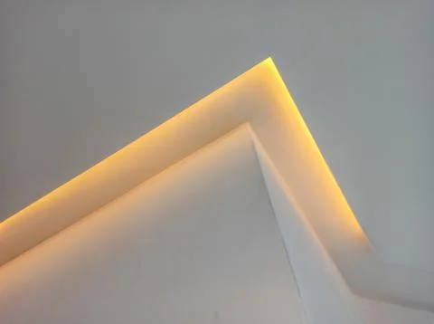 Yellow LED light on white wall. Abstract background. place for logo. Copyspac Stock Photos