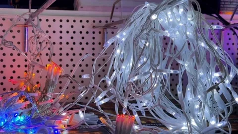 Yellow LED String Lights Piled On Pegboard Shelf, Shopper Inspecting Tangled Stock Footage 322821541