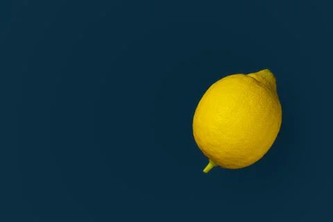 Yellow lemon on a blue background with copyspace. Design, Fine Art, Minimalis Stock Photos