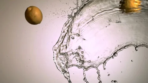 Yellow lemon falling into water splash spray Stock Footage 327179261