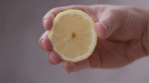 Yellow lemon hand squeeze juice dripping Stock Footage 63597946