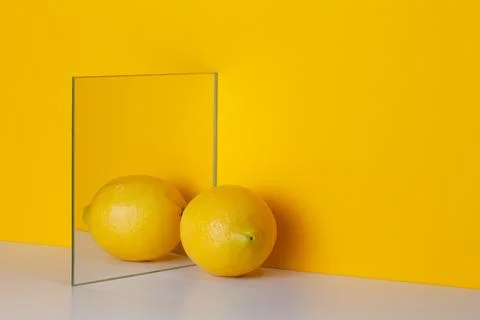 Yellow lemon is reflected in a mirror on a yellow background Stock Illustration