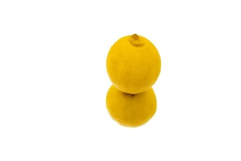 A yellow lemon is reflected on a white surface. Stock Photos