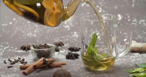Yellow lemon tea from teapot into mint cup, slow motion Stock Footage 142998710