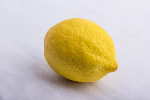 A yellow lemon on a white surface Stock Photos