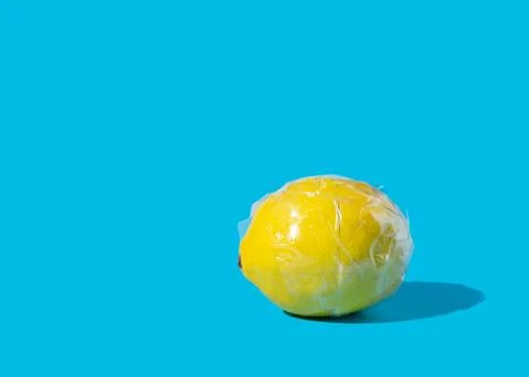 Yellow lemon wrapped in clear plastic tape Stock Photos