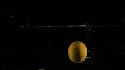 Yellow lemons dropped falling in water with lot of splashes Stock Footage 148737260