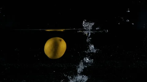 Yellow lemons dropped falling in water with lot of splashes Video stock 148737302