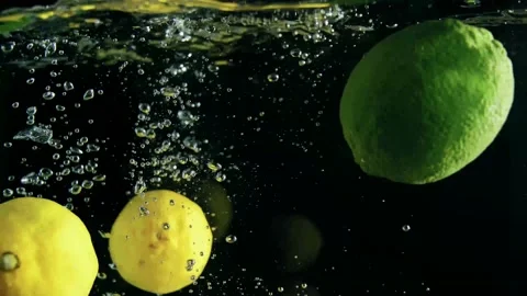 Yellow lemons float in the water Stock Footage 229767860