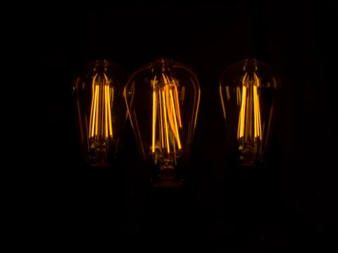 Yellow light bulbs in darkness Stock Photos