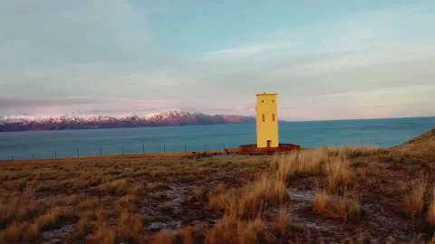 Yellow lighthouse, Geosea spa with the ocean and snowy mountains at the backgrou Stock Footage 261136355