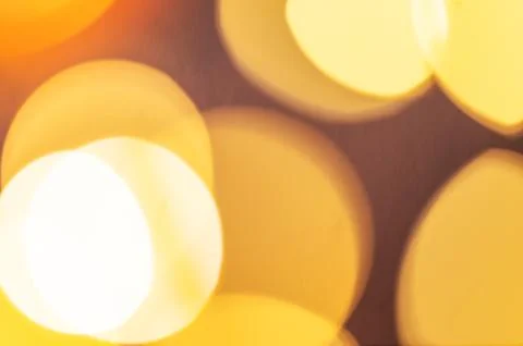 Yellow lights with a bokeh effect on a dark background. Stock Photos